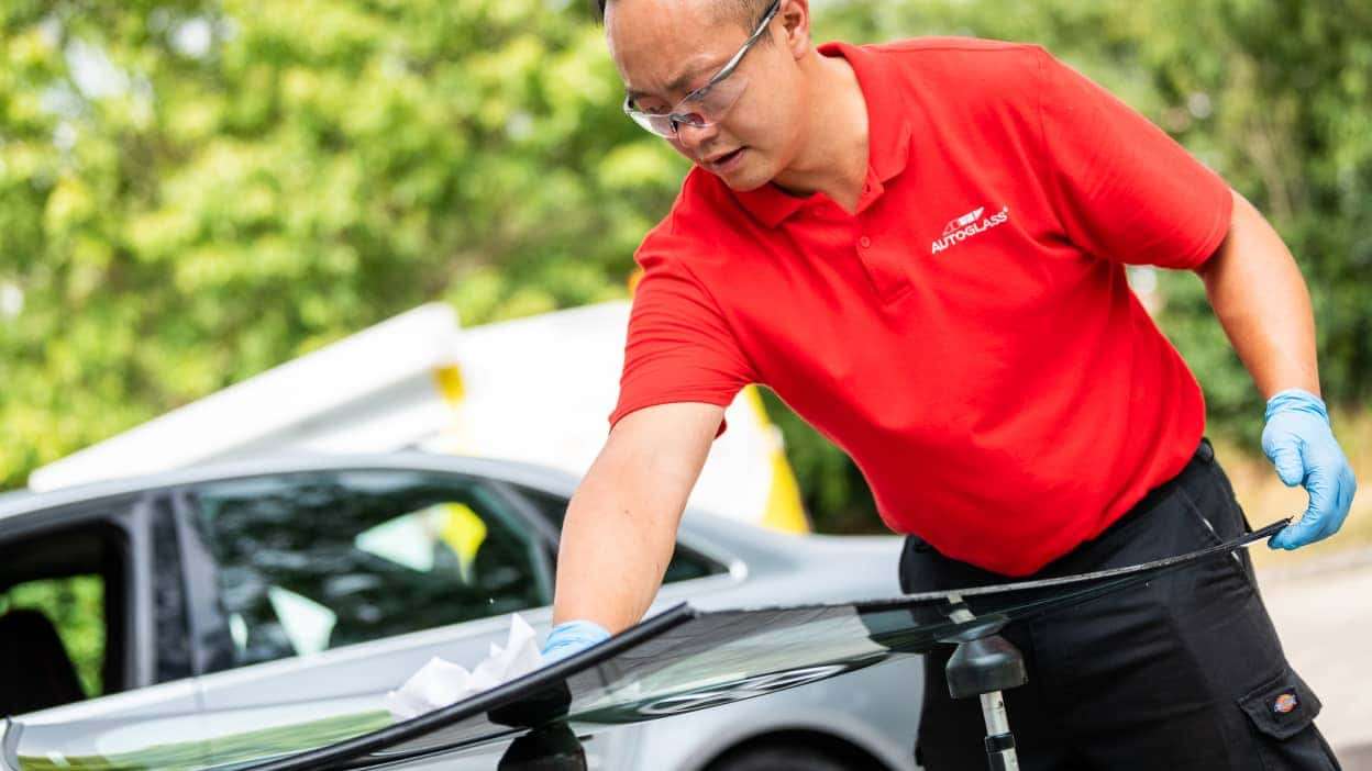 A technician at Autoglass® carrying out a side window replacement