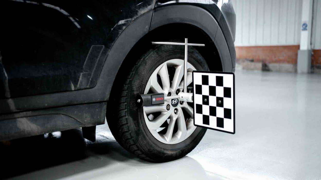 ADAS recalibration tool attached to wheel of vehicle