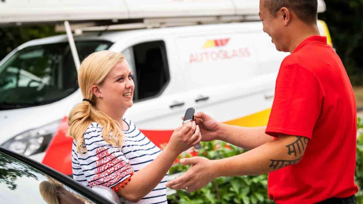 A customer handing over keys to a technician at Autoglass