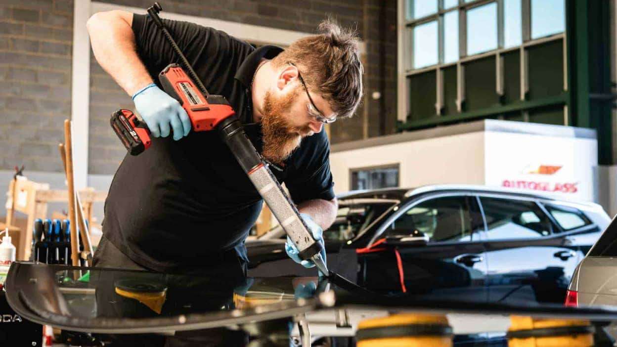 An Autoglass technician replacing a vehicle windscreen